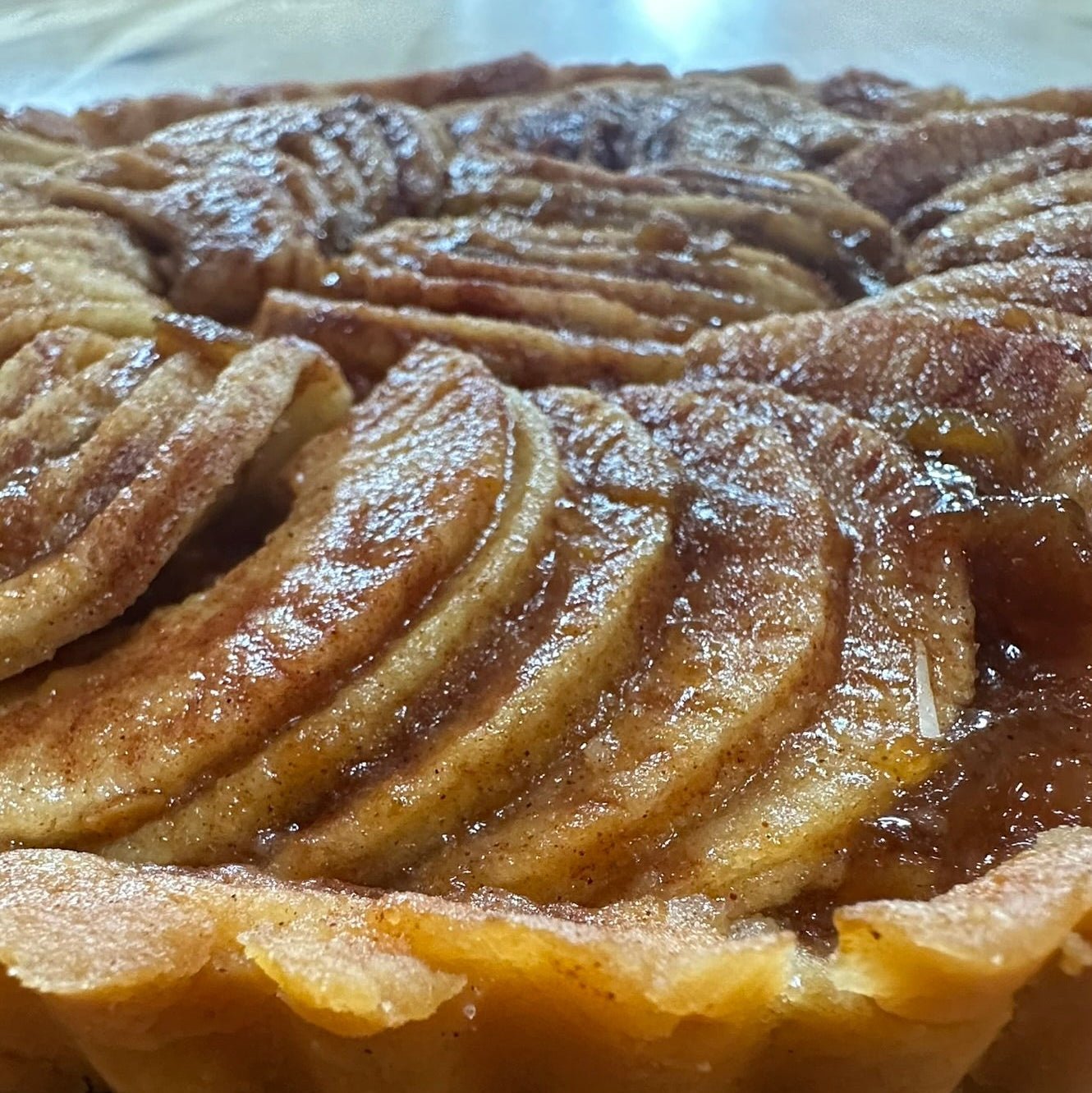 Apple Sourdough Tart – SEBAlicious™ Artisan Dessert (Des Plaines, IL) - Artisan Real Sourdough Bread Chef SebaArtisan Real Sourdough Bread Chef SebaArtisan Real Sourdough Bread Chef SebaSEBA-DS-ASTClose - up of artisan apple tart with thinly sliced caramelized apples and flaky golden crust by Chef SEBA