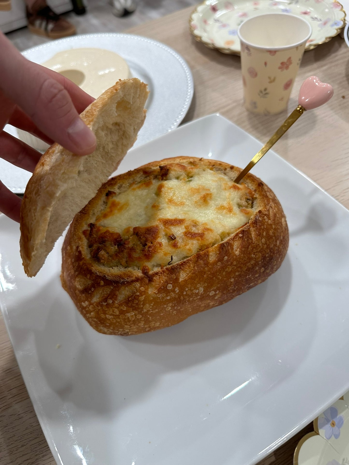 Stuffed artisan sourdough bread loaf opened to reveal filling prepared by Chef Seba. Fresh baked artisan sourdough bread loaf opened to reveal a warm savory filling, served and prepared by Chef Seba.