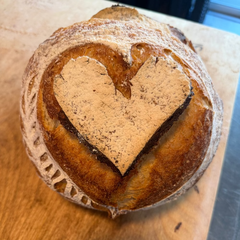 Polish wedding bread decorated with a heart and artisan wheat scoring