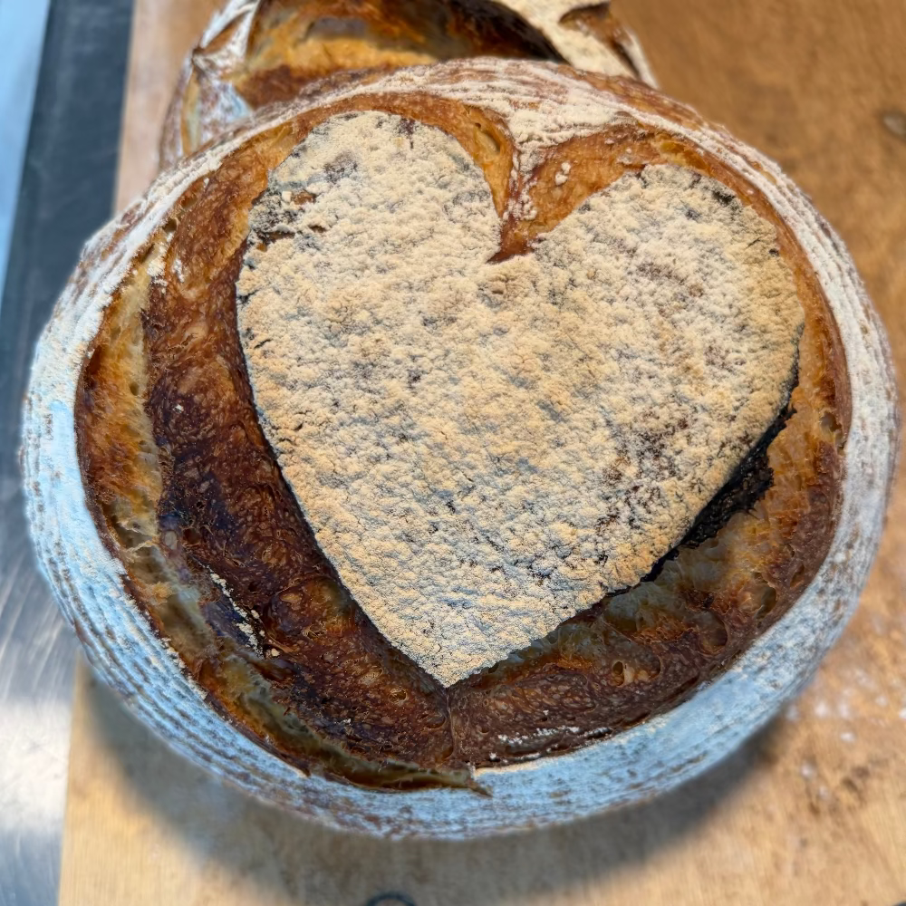 Top view of Polski Chleb Weselny artisan sourdough decorated with a large heart