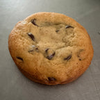 SEBA Artisan Sourdough Chocolate Chip Cookie - Artisan Real Sourdough Bread Chef SebaArtisan Real Sourdough Bread Chef SebaArtisan Real Sourdough Bread Chef SebaSEBA-CCC-120A single chocolate chip cookie on a brushed metal surface.