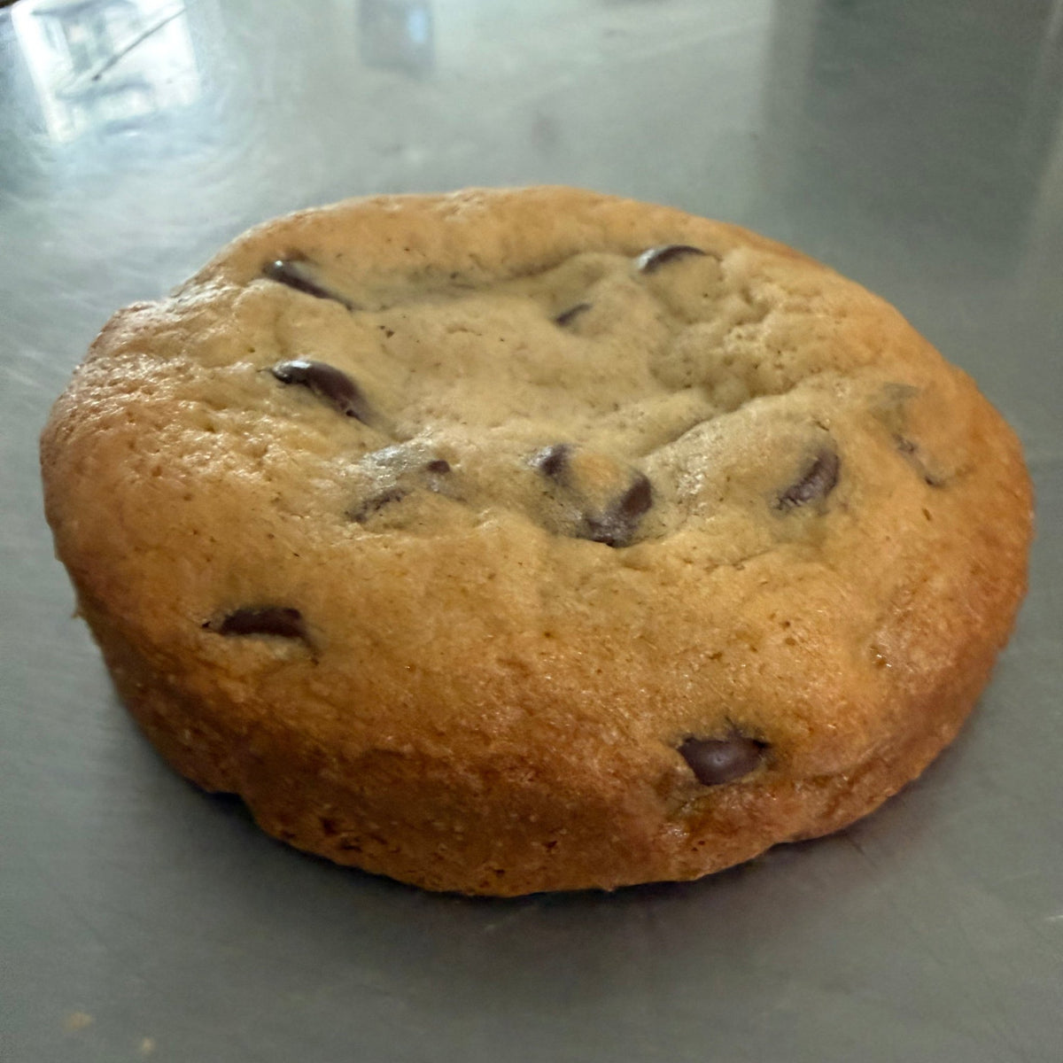 SEBA Artisan Sourdough Chocolate Chip Cookie - Artisan Real Sourdough Bread Chef SebaArtisan Real Sourdough Bread Chef SebaArtisan Real Sourdough Bread Chef SebaSEBA-CCC-120A single chocolate chip cookie on a gray countertop.