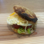 SEBAlicious™ Artisan Sourdough English Muffins Tuesday special - Artisan Real Sourdough Bread Chef SebaArtisan Real Sourdough Bread Chef SebaArtisan Real Sourdough Bread Chef SebaSEBA-EM-4-SD4 packA small toasted sandwich with a fried egg, tomato, avocado, and cheese on a wooden board on a wooden table.